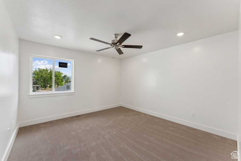 Empty room featuring ceiling fan, carpet, baseboards, and recessed lighting