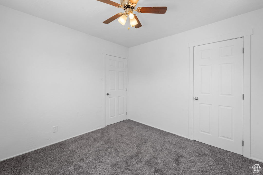 Empty room featuring carpet flooring and ceiling fan