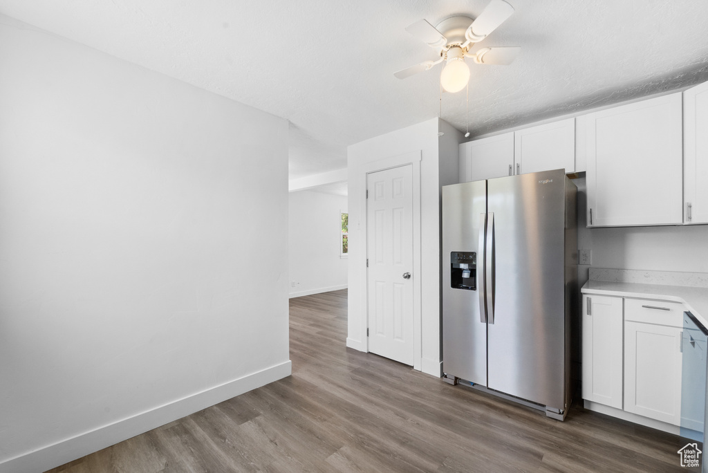 Kitchen featuring stainless steel fridge, a ceiling fan, wood finished floors, and white cabinets