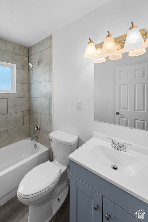 Full bathroom featuring vanity, washtub / shower combination, and wood finished floors
