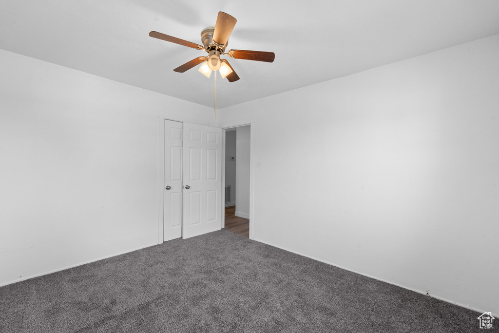 Unfurnished bedroom featuring carpet, ceiling fan, and a closet