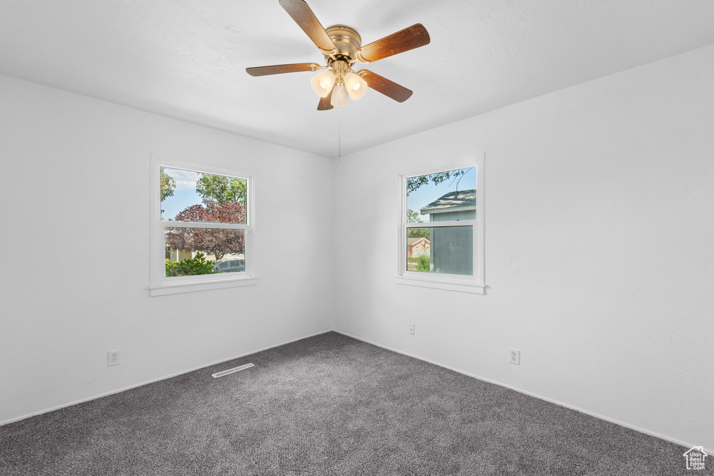 Unfurnished room featuring carpet and a ceiling fan