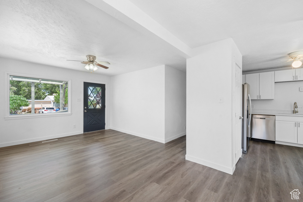 Foyer entrance with a ceiling fan and wood finished floors