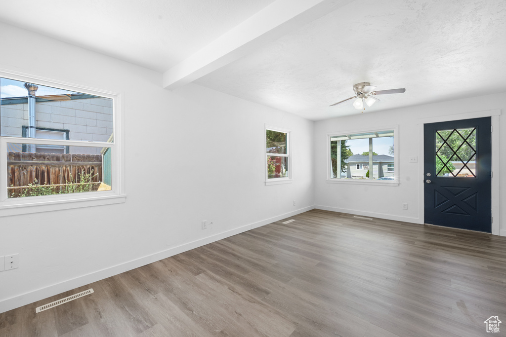 Entryway with ceiling fan, wood finished floors, and beam ceiling