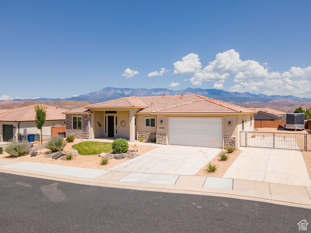 View of front of house featuring stone siding, a gate, and a mountain view