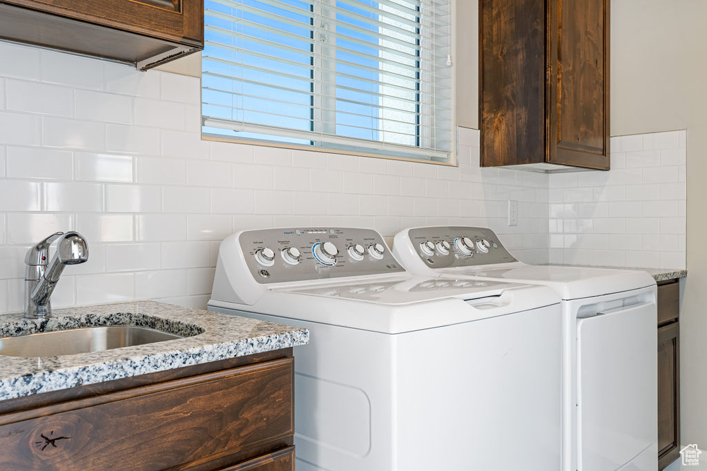 Washroom featuring washing machine and clothes dryer and cabinet space