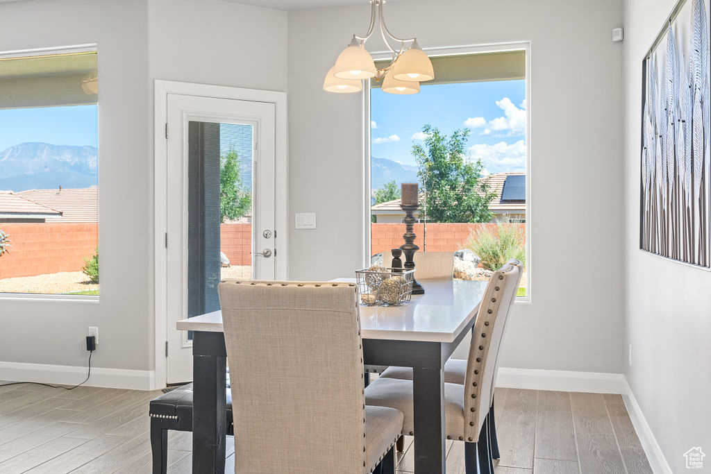 Dining space featuring wood finished floors, baseboards, a mountain view, and a chandelier