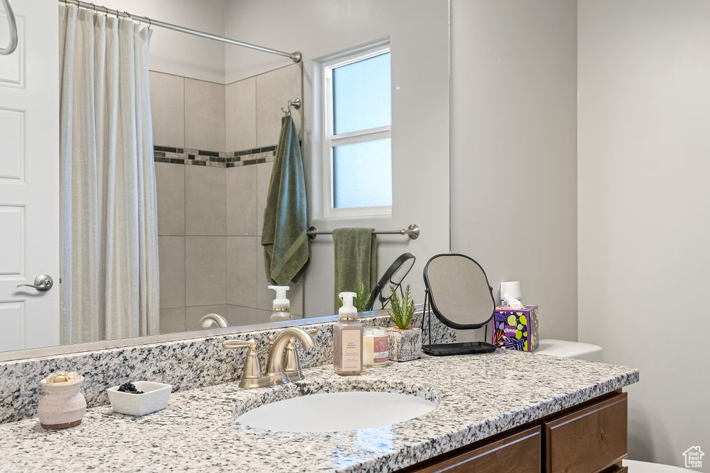 Bathroom featuring vanity, a shower with shower curtain, and toilet