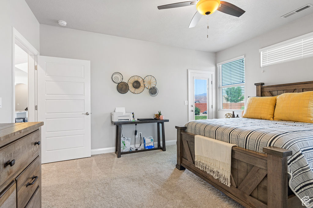 Bedroom featuring light colored carpet, access to outside, baseboards, and a ceiling fan