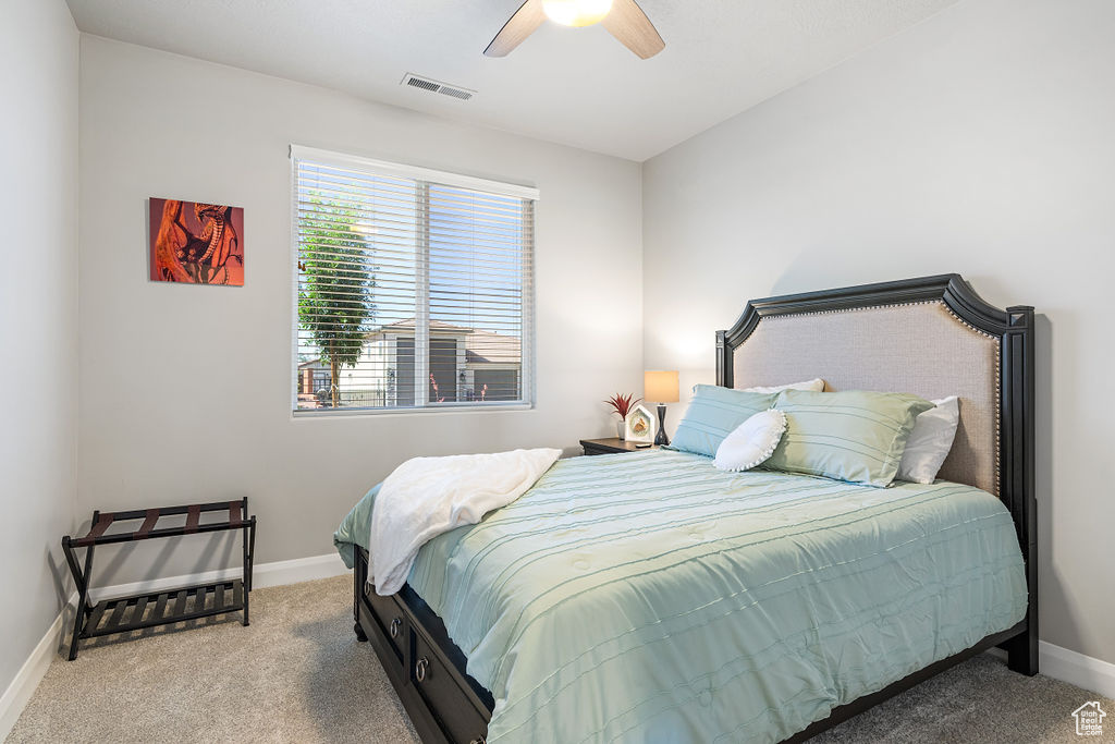 Bedroom with carpet flooring, baseboards, and a ceiling fan