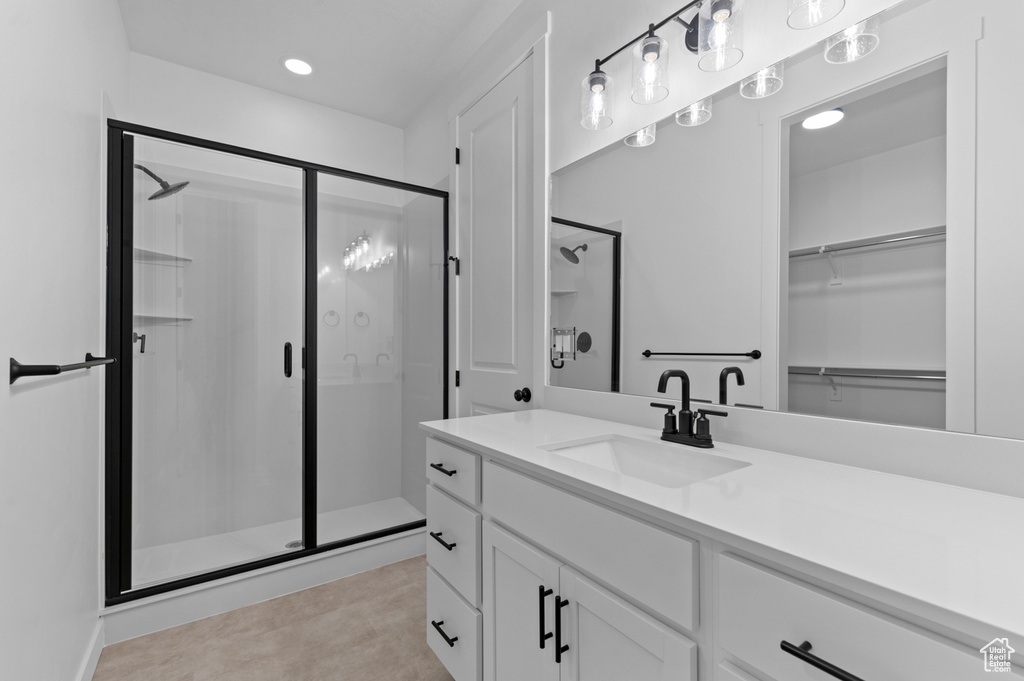 Full bath featuring a shower stall, vanity, recessed lighting, and a walk in closet