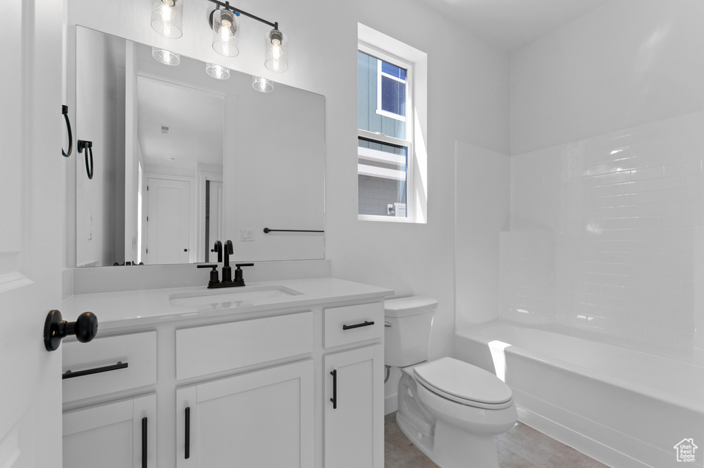 Bathroom featuring toilet, vanity, and shower / tub combination