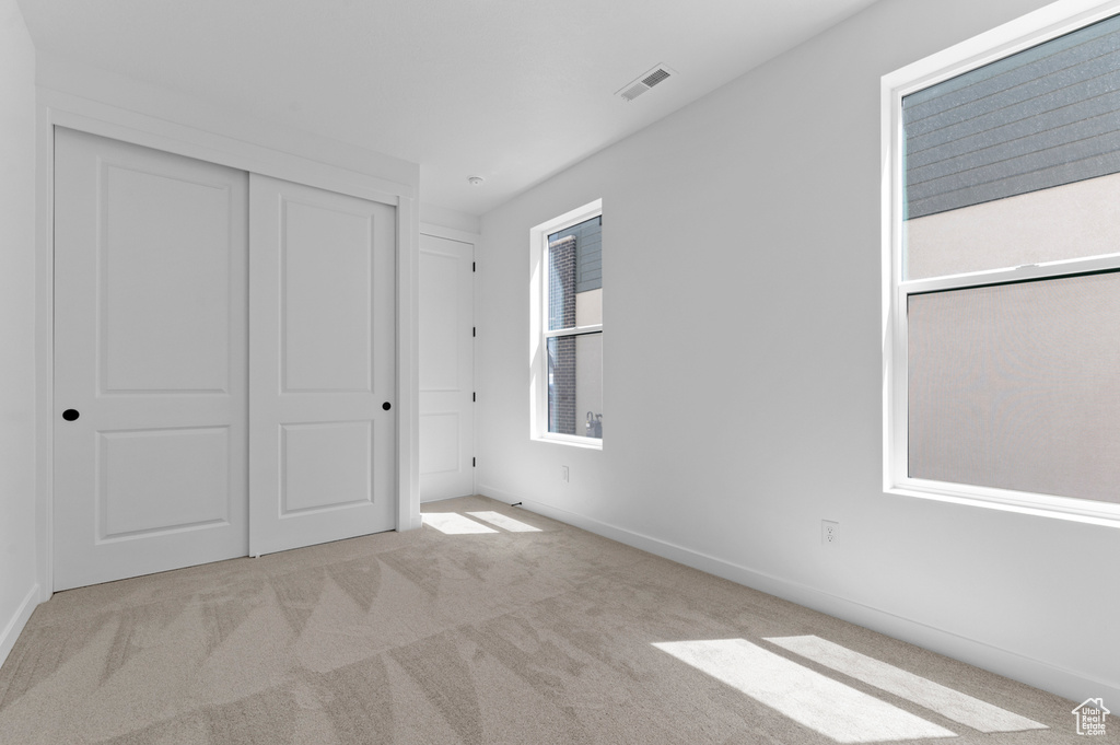 Unfurnished bedroom with carpet floors, baseboards, and a closet