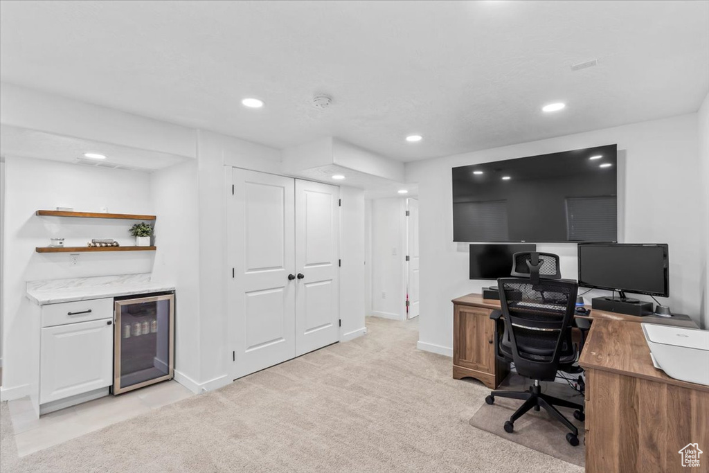 Home office with beverage cooler, a bar, recessed lighting, baseboards, and light carpet
