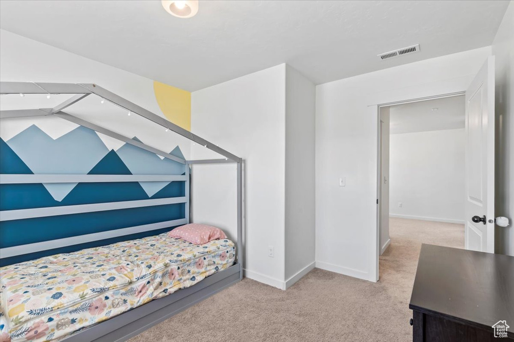 Bedroom with light carpet and baseboards