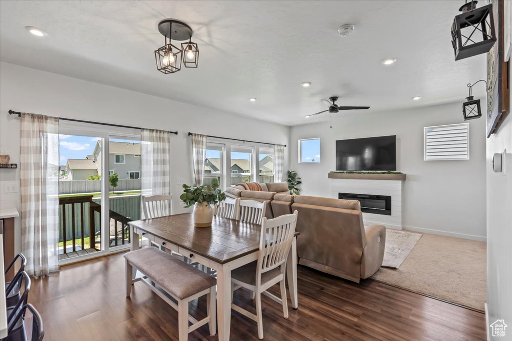 Dining area featuring a glass covered fireplace, ceiling fan, recessed lighting, baseboards, and wood finished floors