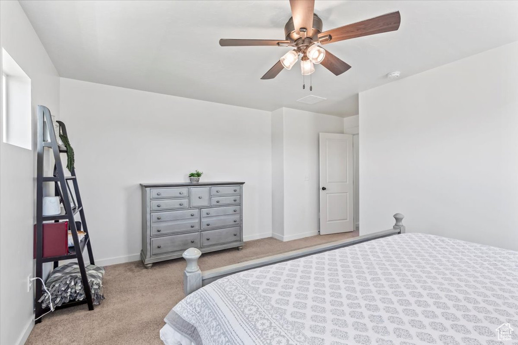 Bedroom featuring light carpet, baseboards, and a ceiling fan