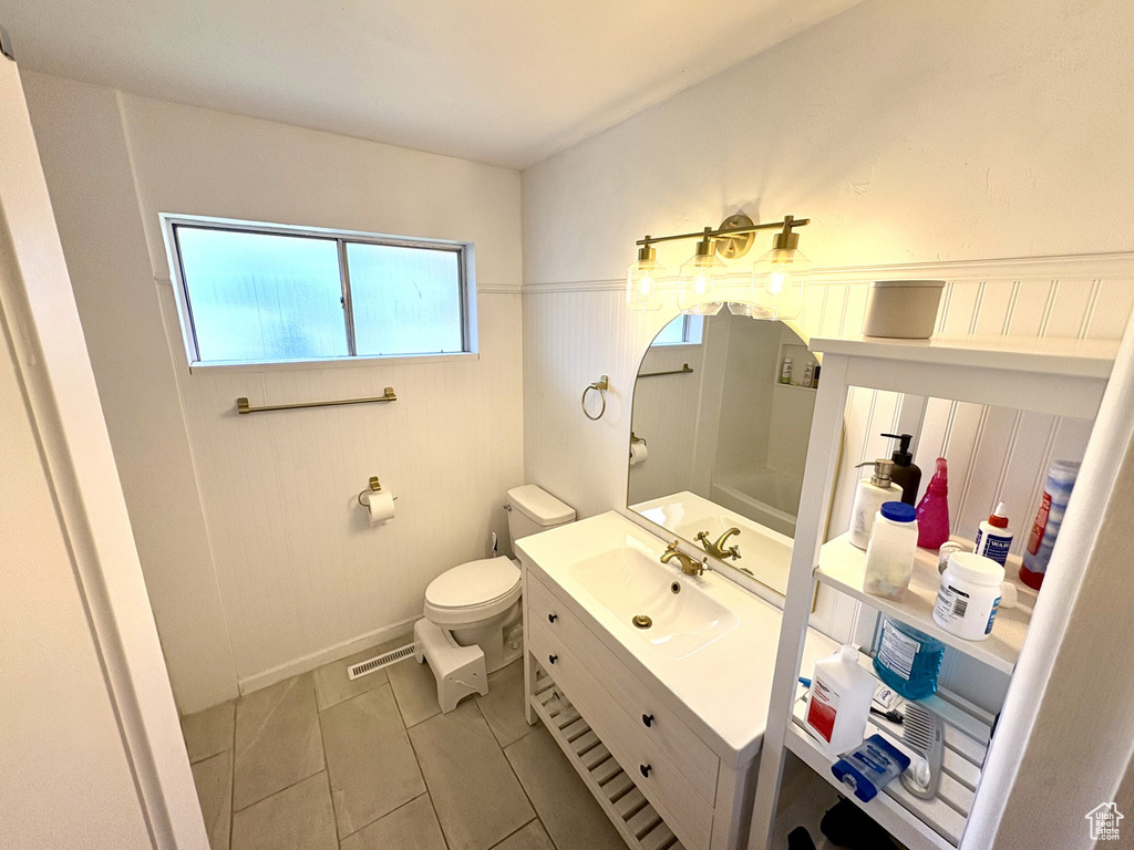 Bathroom with toilet, vanity, and tile patterned flooring