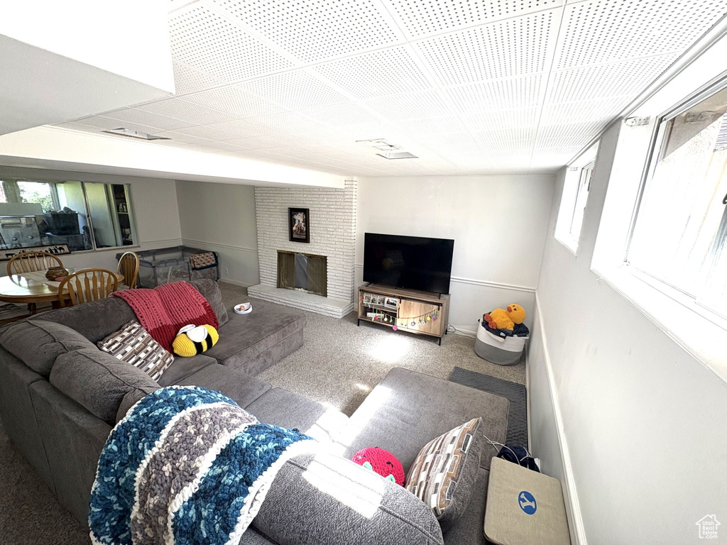Carpeted living room with baseboards and a brick fireplace