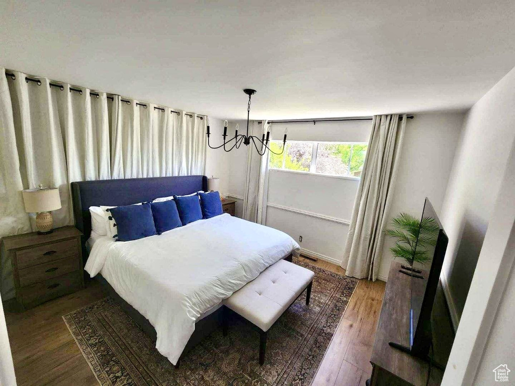 Bedroom featuring a chandelier and wood finished floors