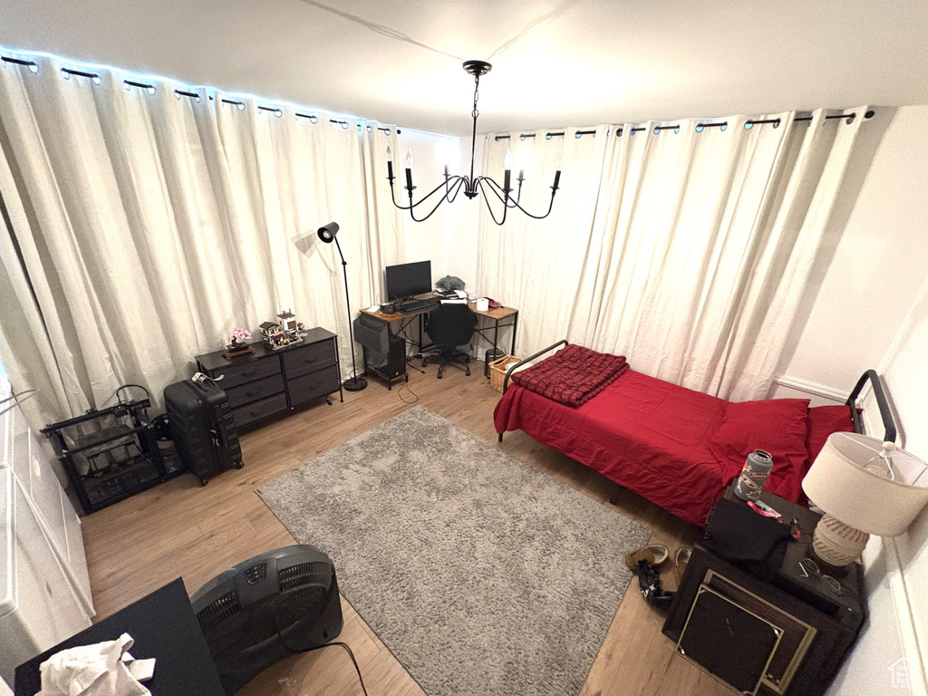 Bedroom with wood finished floors and an office area