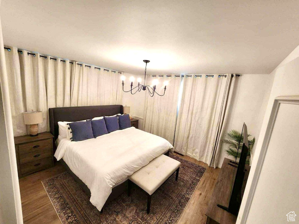 Bedroom with a chandelier and wood finished floors