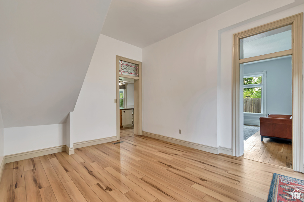 Bonus room featuring light wood-style floors and baseboards