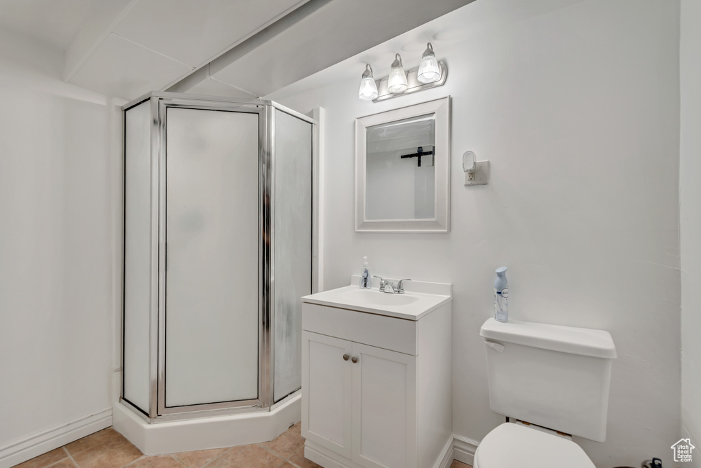 Full bathroom featuring vanity, a stall shower, toilet, and tile patterned floors