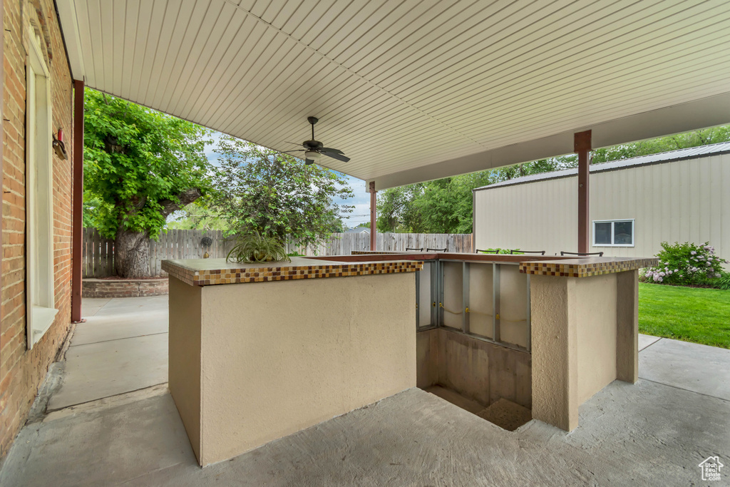 Fenced backyard featuring a patio and ceiling fan