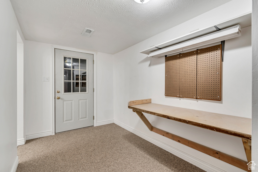 Corridor featuring carpet flooring, baseboards, and a textured ceiling