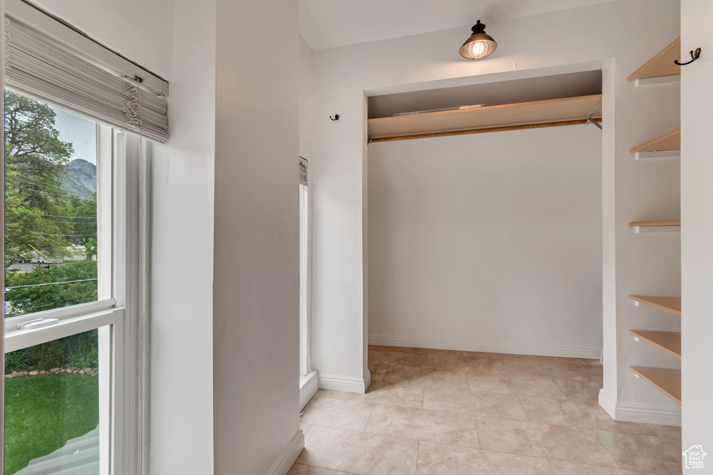 Corridor with light tile patterned floors and baseboards