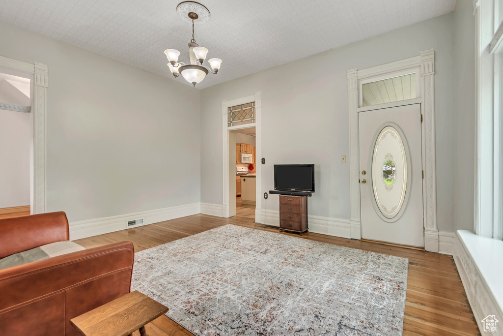 Living room featuring a chandelier, wood finished floors, and baseboards