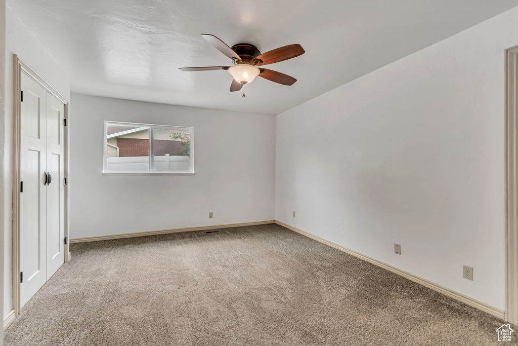 Unfurnished bedroom featuring carpet, baseboards, and ceiling fan