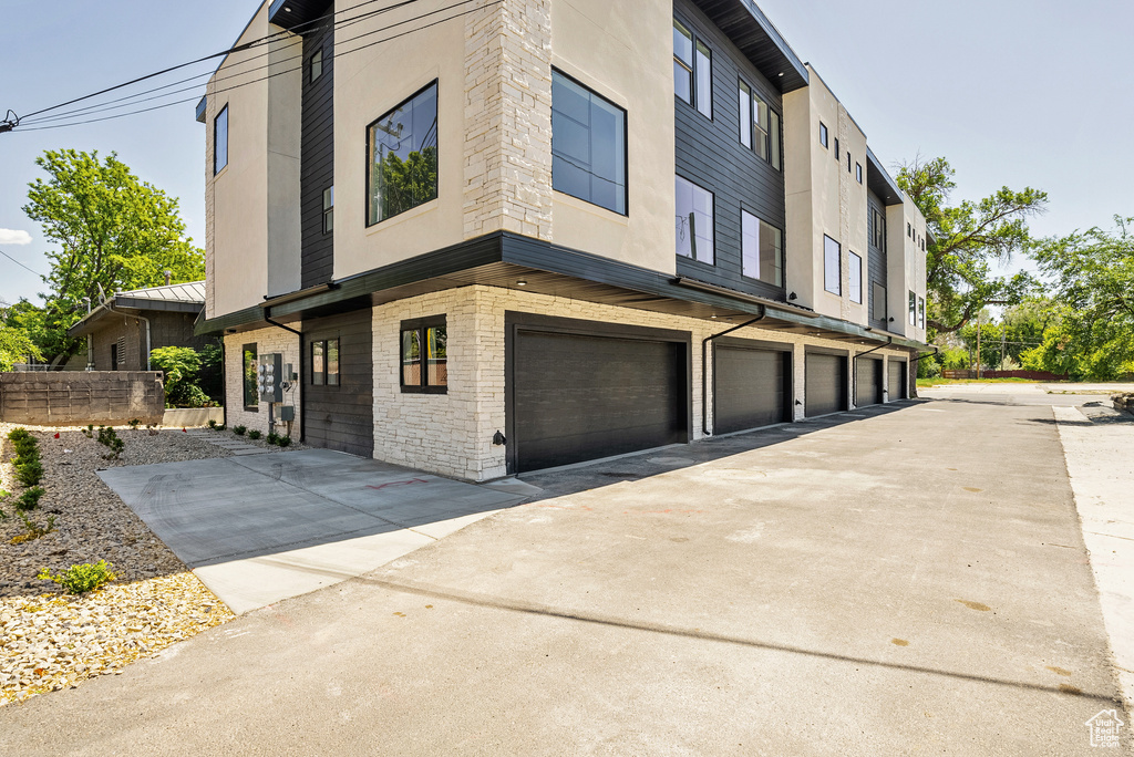 View of building exterior with a garage and driveway