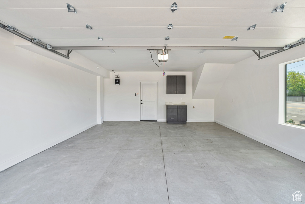 Garage with a garage door opener and baseboards