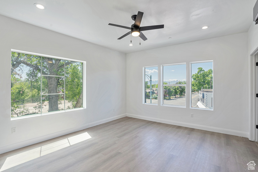 Spare room with plenty of natural light, wood finished floors, a ceiling fan, baseboards, and recessed lighting