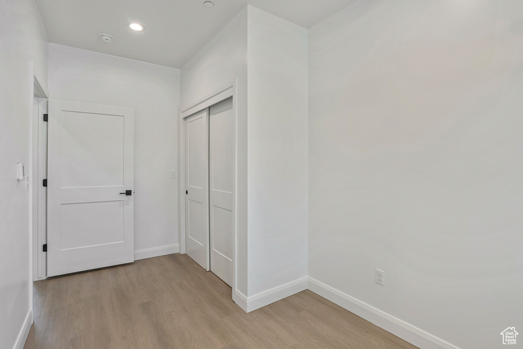 Hallway with baseboards, light wood finished floors, and recessed lighting