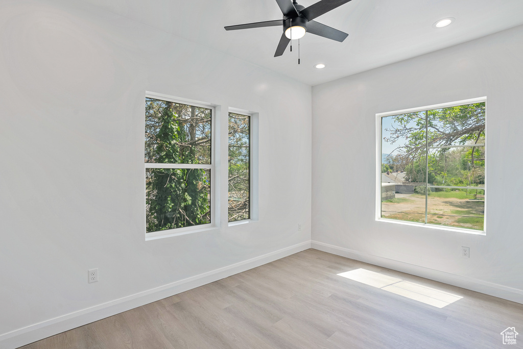 Unfurnished room featuring baseboards, light wood finished floors, a ceiling fan, and recessed lighting