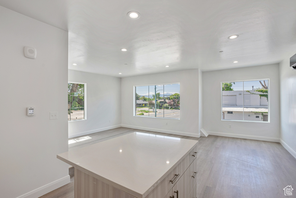 Kitchen featuring recessed lighting, light wood finished floors, open floor plan, baseboards, and light countertops