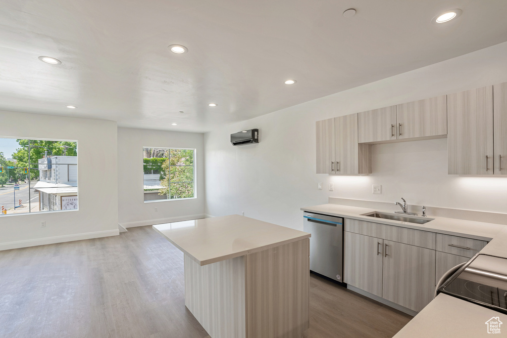 Kitchen with dishwasher, a sink, light wood-style flooring, light countertops, and recessed lighting