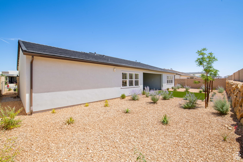 Rear view of house featuring stucco siding and a fenced backyard