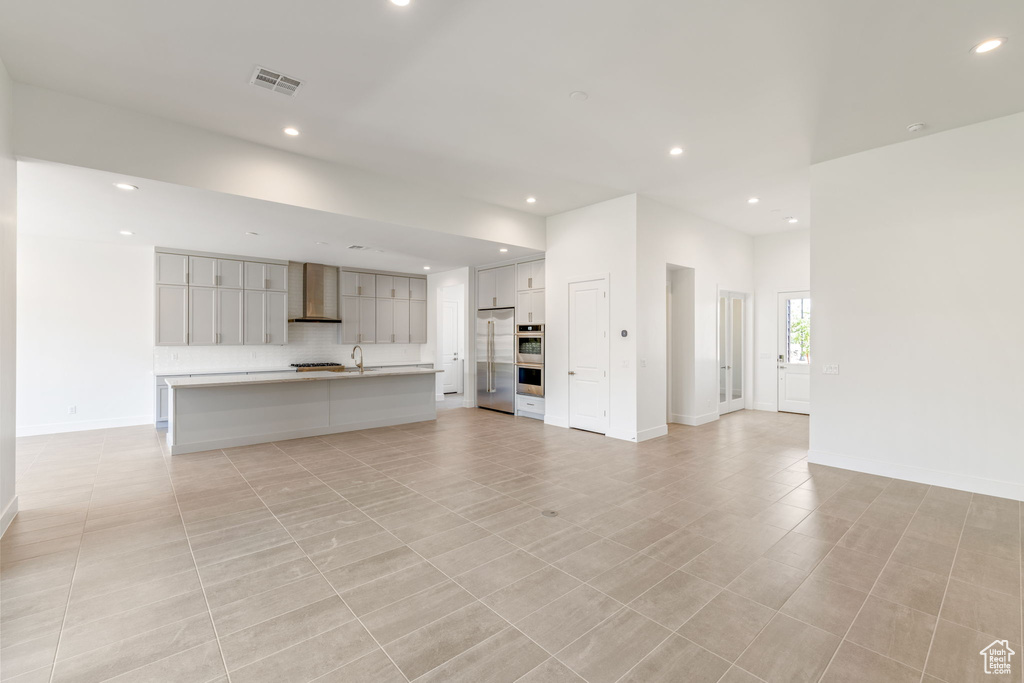 Unfurnished living room with recessed lighting, baseboards, and a sink