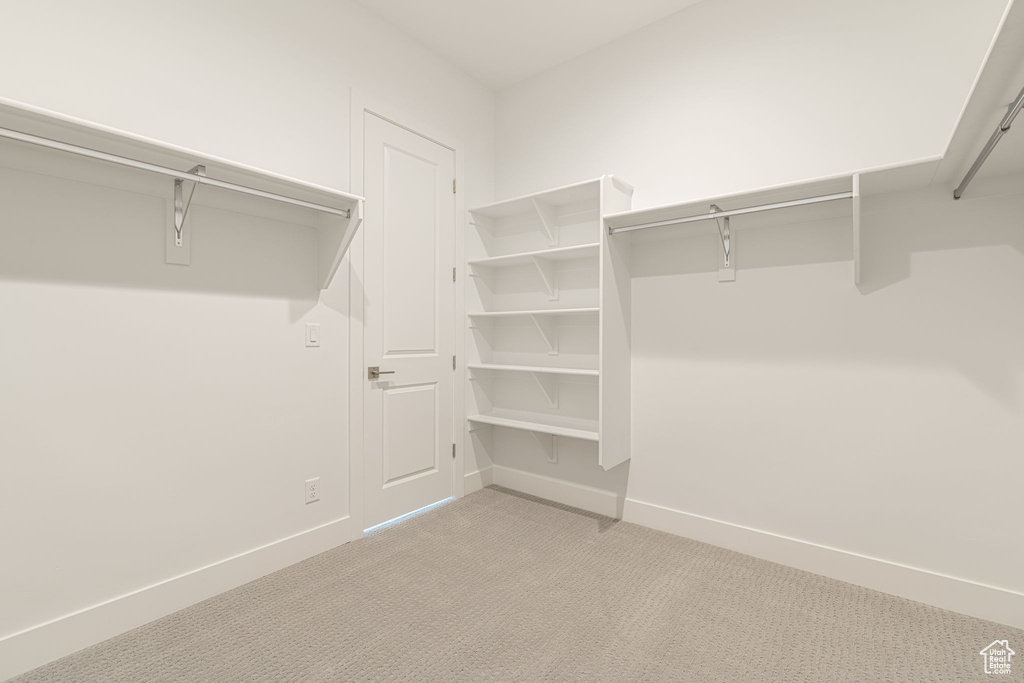 Walk in closet with light carpet