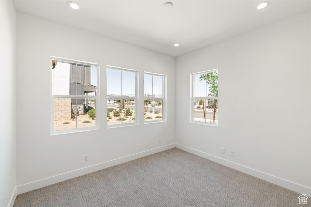 Spare room with light colored carpet, baseboards, and recessed lighting