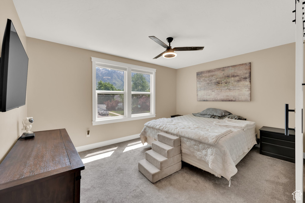 Carpeted bedroom featuring baseboards and ceiling fan