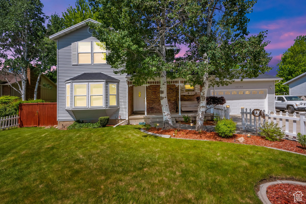View of front of house with a porch, driveway, and an attached garage