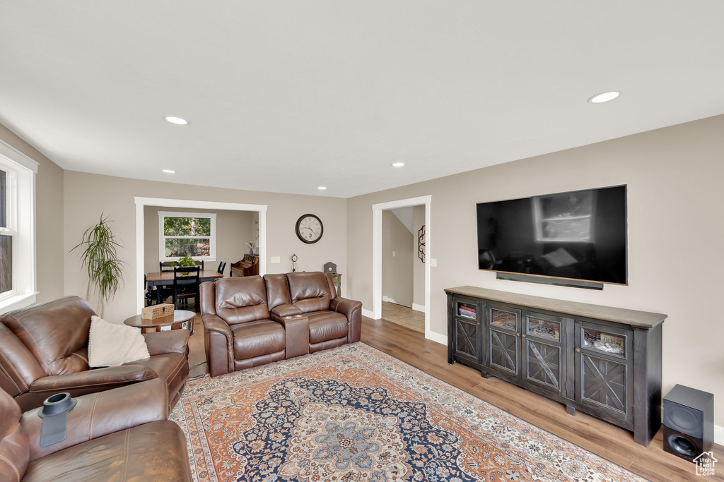 Living room with light wood finished floors, recessed lighting, and baseboards