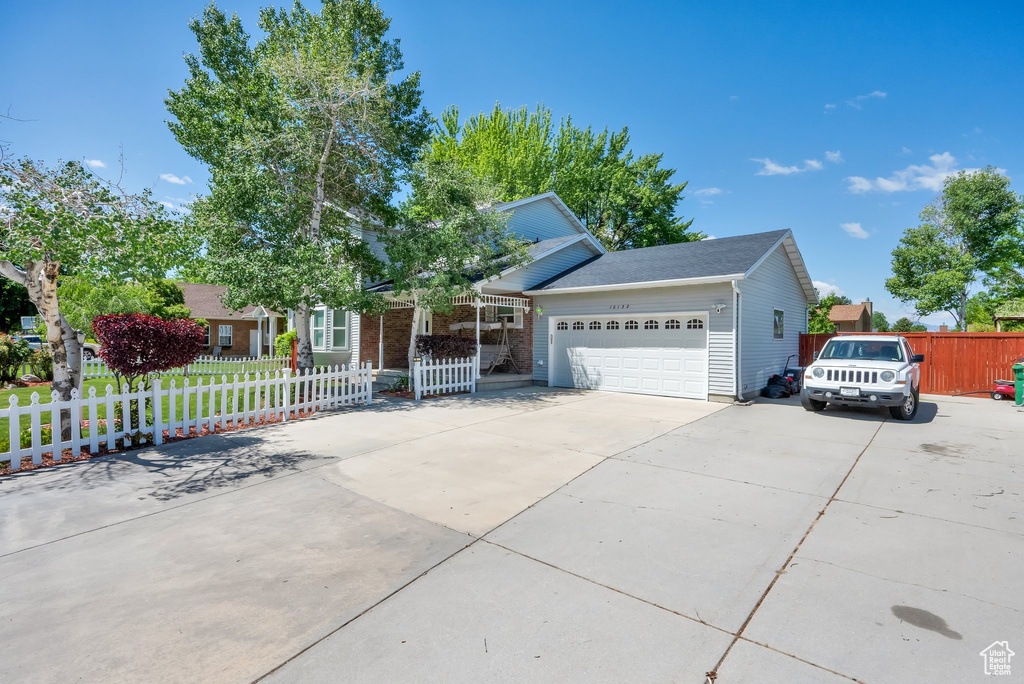 View of front of home with an attached garage, driveway, and brick siding
