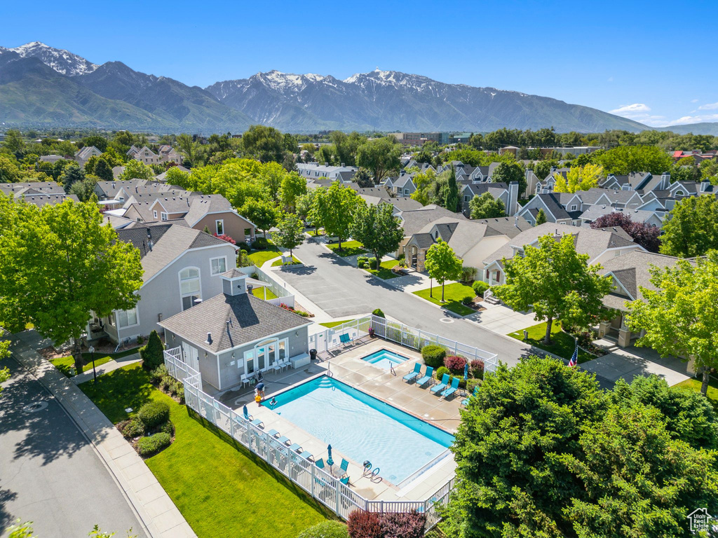 Aerial view of residential area featuring a pool area and a mountainous background