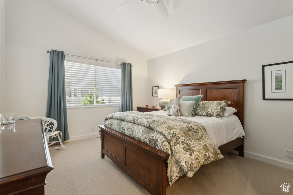 Bedroom with light carpet, vaulted ceiling, baseboards, and ceiling fan